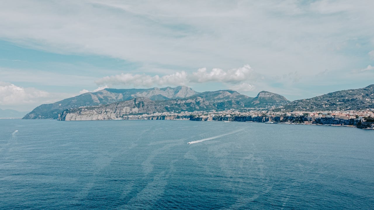 Spectacular aerial view of Sorrento's stunning coastline and blue sea under a vibrant sky.